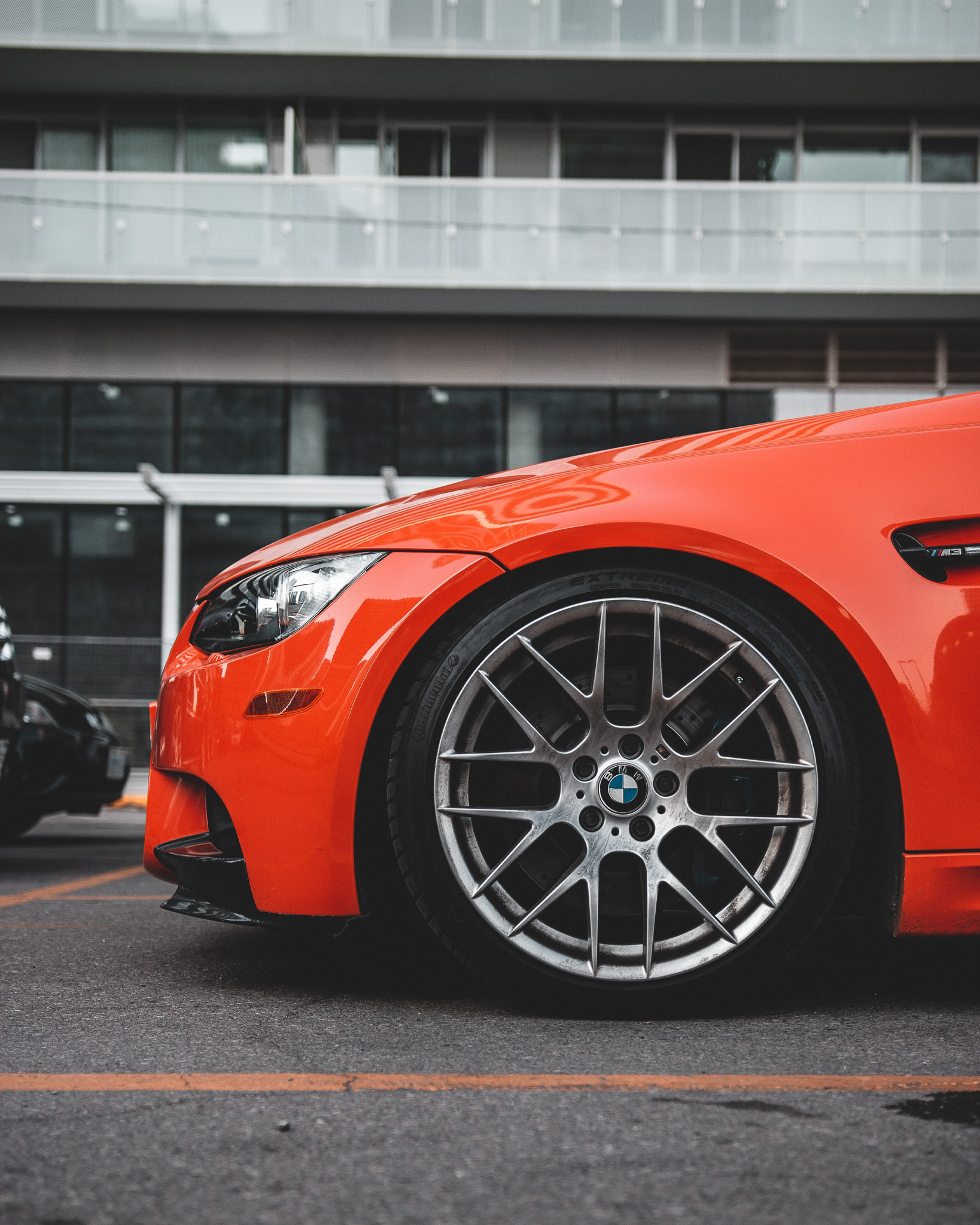 This image shows the side profile an orange car with designer wheels.