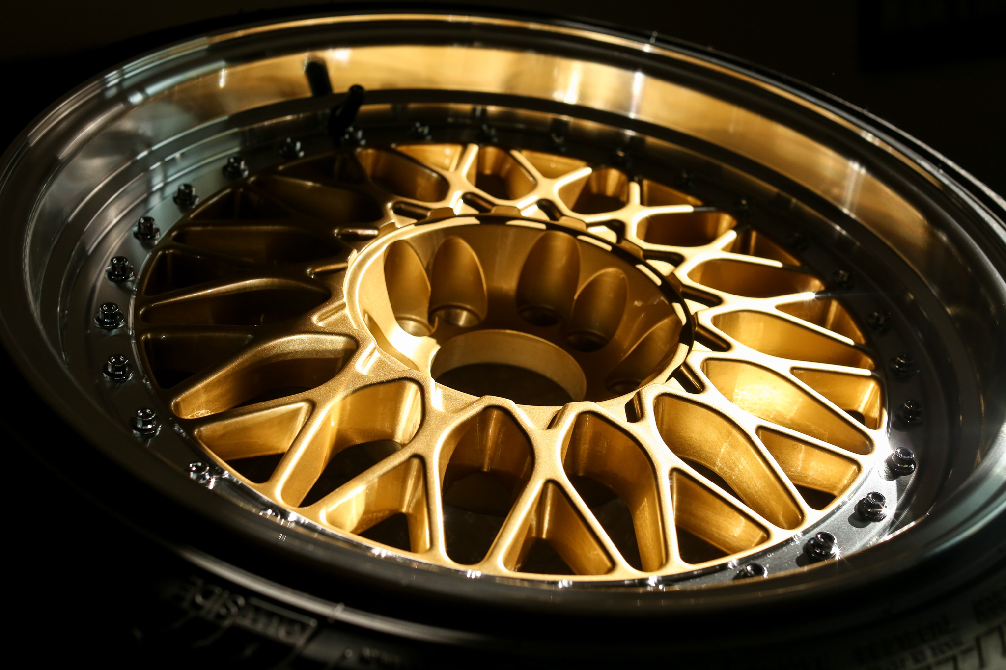 This image shows a gold multi-spoke wheel. The light glistens on the metal.